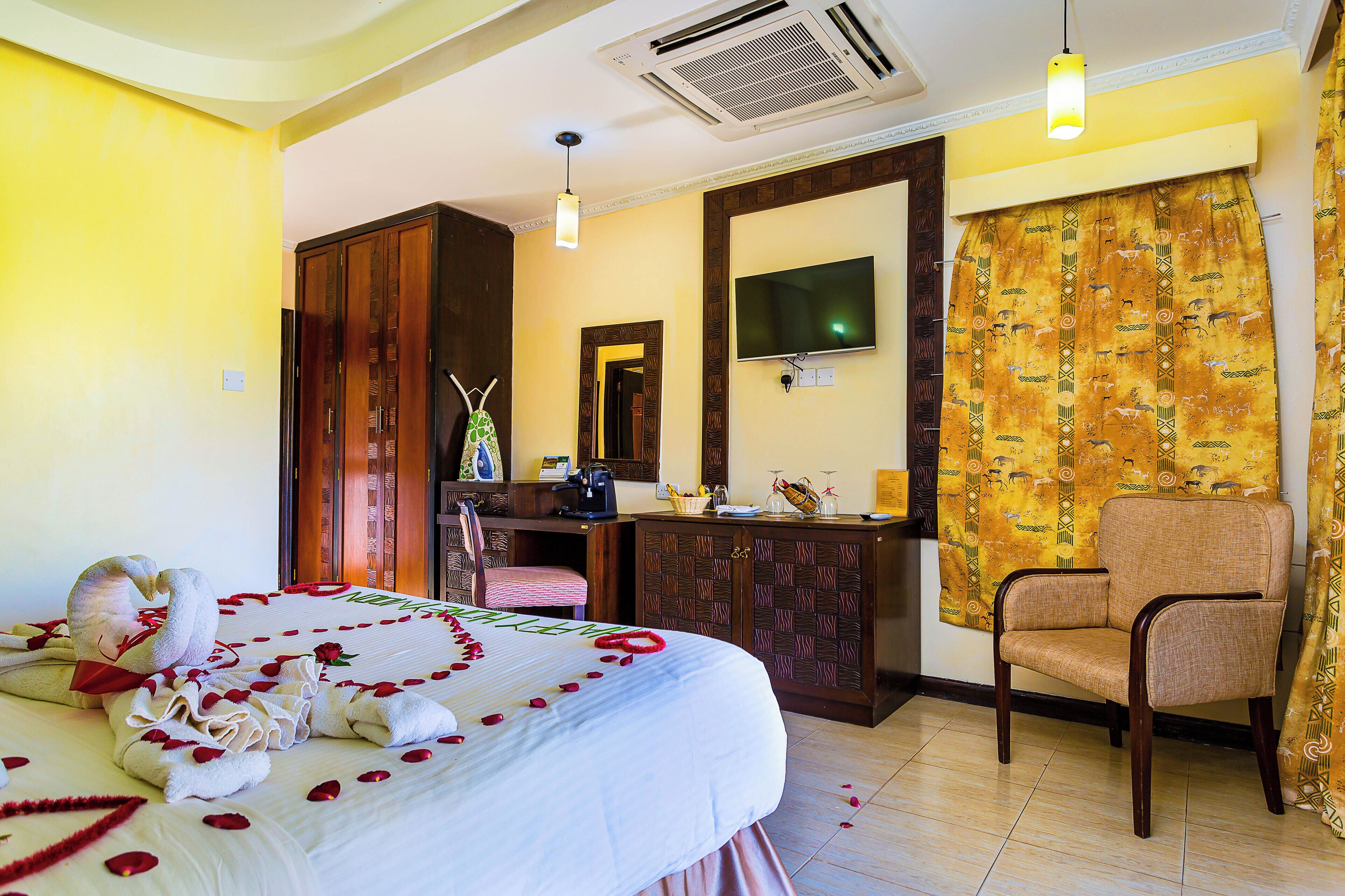A hotel room with a bed, a desk, a chair, a television, and a bathroom.