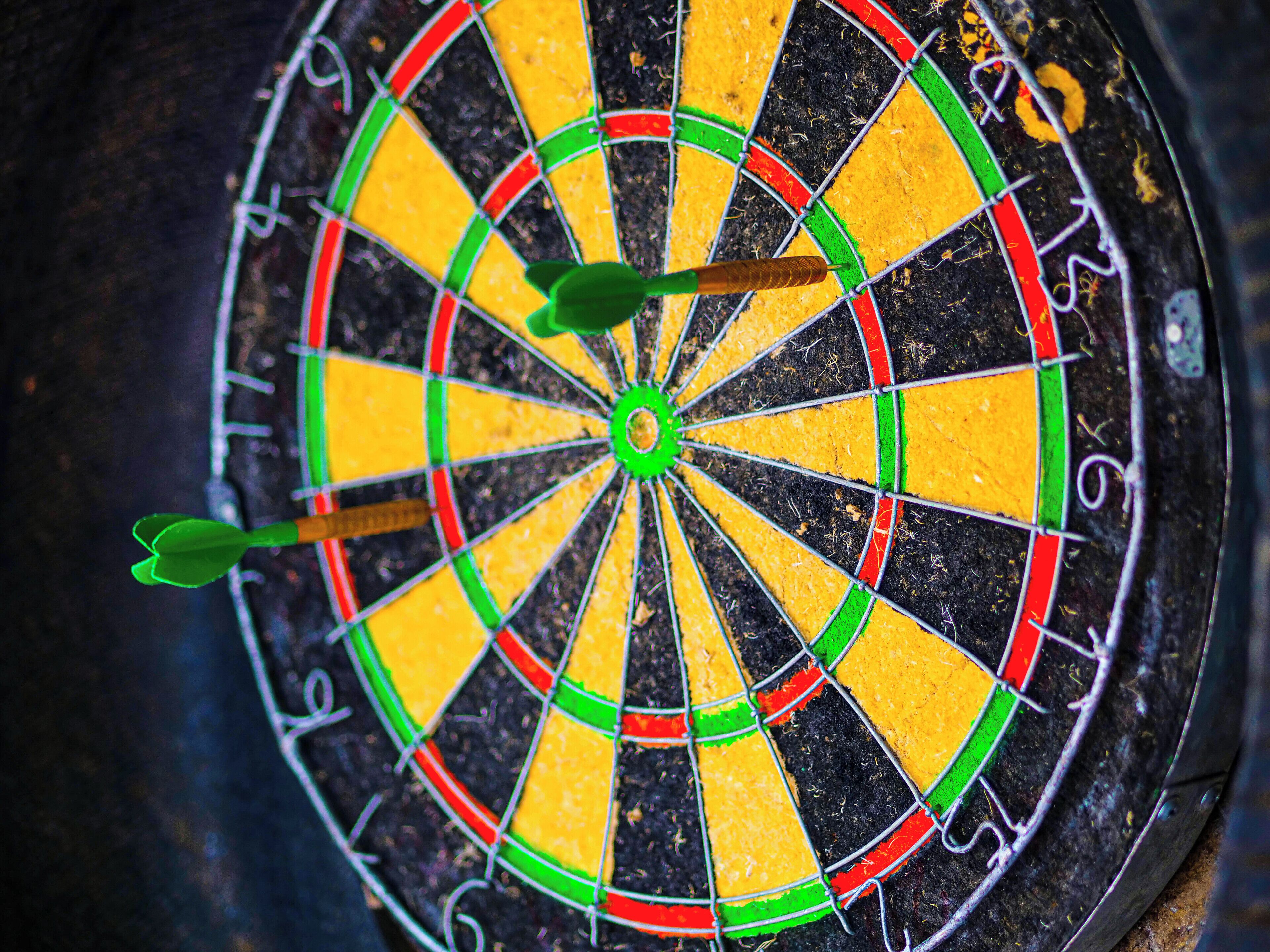 A dartboard with three darts in the center.