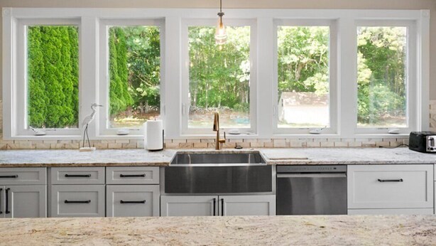 A kitchen with a large window, a sink, and a dishwasher. - New Build, Private Beach, Central Air, Big Yard, Firepit, Wine Bar (Narragansett)
