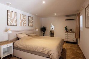A bedroom with a bed, bedside table, dresser, mirror, and wall art. - Villa Gageac - 6 people - Upscale - Sarlat / Roque Gageac (24) (La Roque-Gageac)