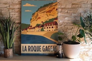 A framed artwork of a coastal town with a cliff, labeled 'LA ROQUE GAGEAC.'