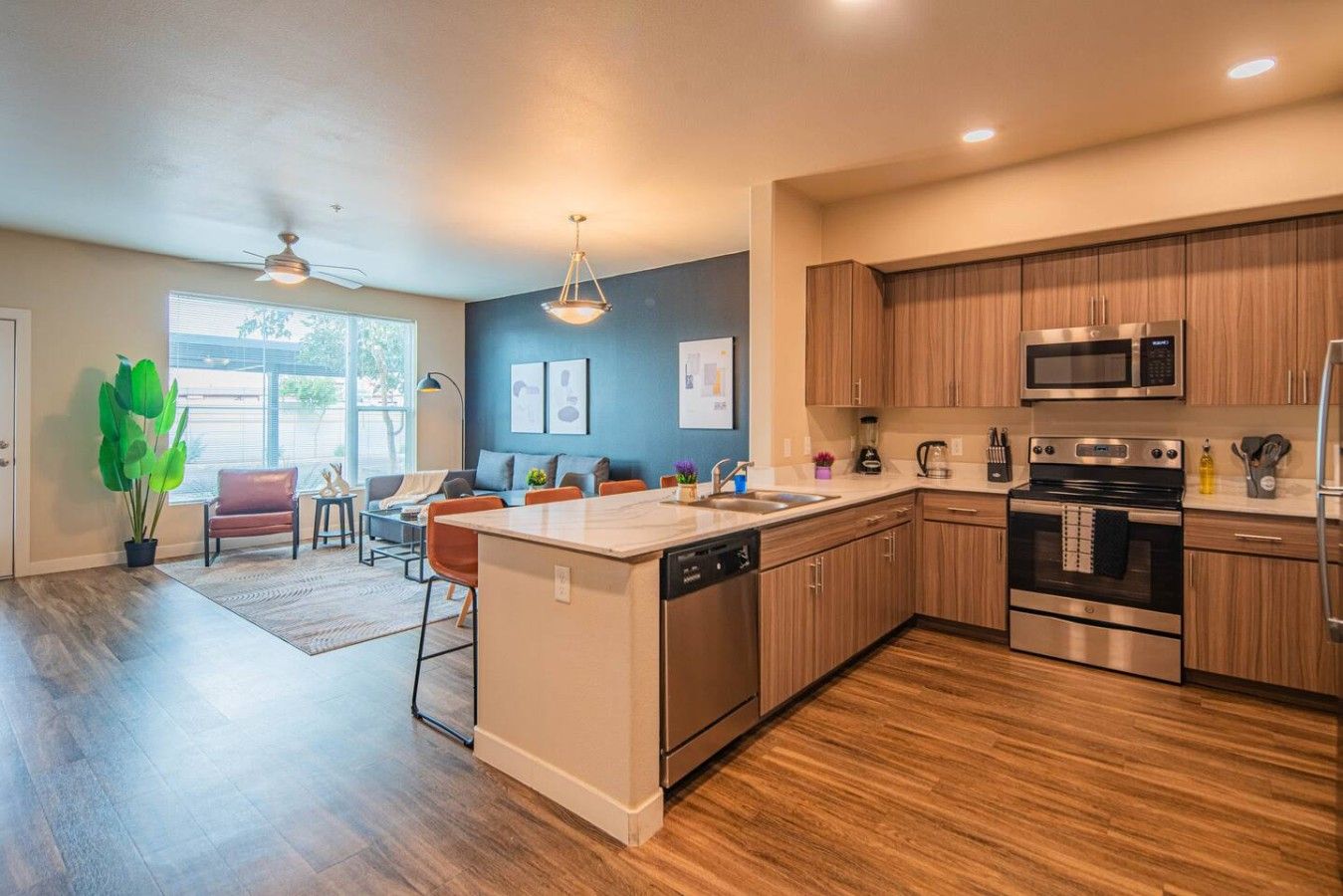 A modern kitchen with wooden cabinets, stainless steel appliances, and a central island.