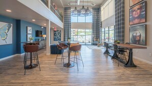 A spacious, modern interior with high ceilings, a central dining area with bar stools, and artwork on the walls. - Tempe DT Escape | Pool, Gym, W/D, Parking Sleeps 4 (Tempe)