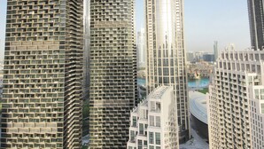 Un edificio de gran altura con la marca "EMAAR", con fachada de vidrio moderna y un elemento vertical destacado.