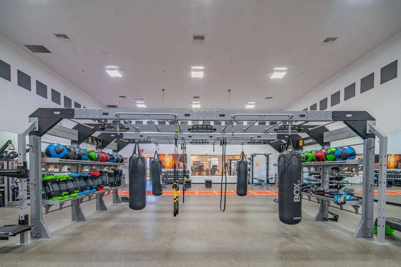 A gym with weightlifting equipment, punching bags, and exercise balls.