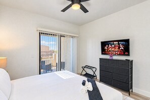 A hotel room with a bed, a TV mounted on the wall, a dresser, and a window with blinds. - 3Min To Stadium w/ Balcony Pool Gym Parking W/D (Glendale)