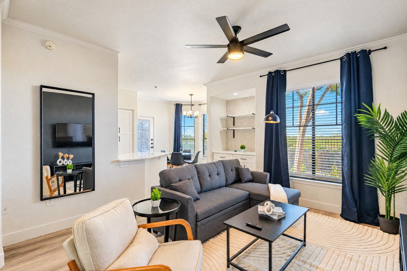 A modern living room with a sofa, a coffee table, and a TV mounted on the wall.