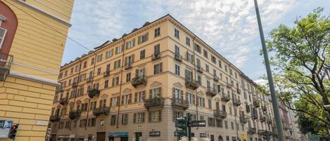 A multi-story building with a classic architectural style, featuring balconies and a ground-level entrance.