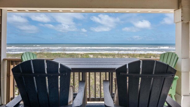 A covered outdoor seating area with a view of the ocean.