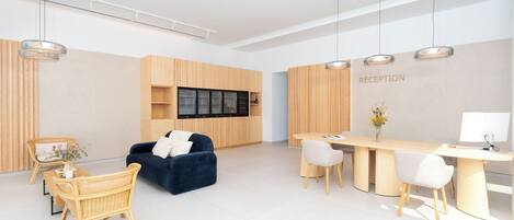 Uma área de recepção moderna, com balcão, assentos e um painel fixado na parede.