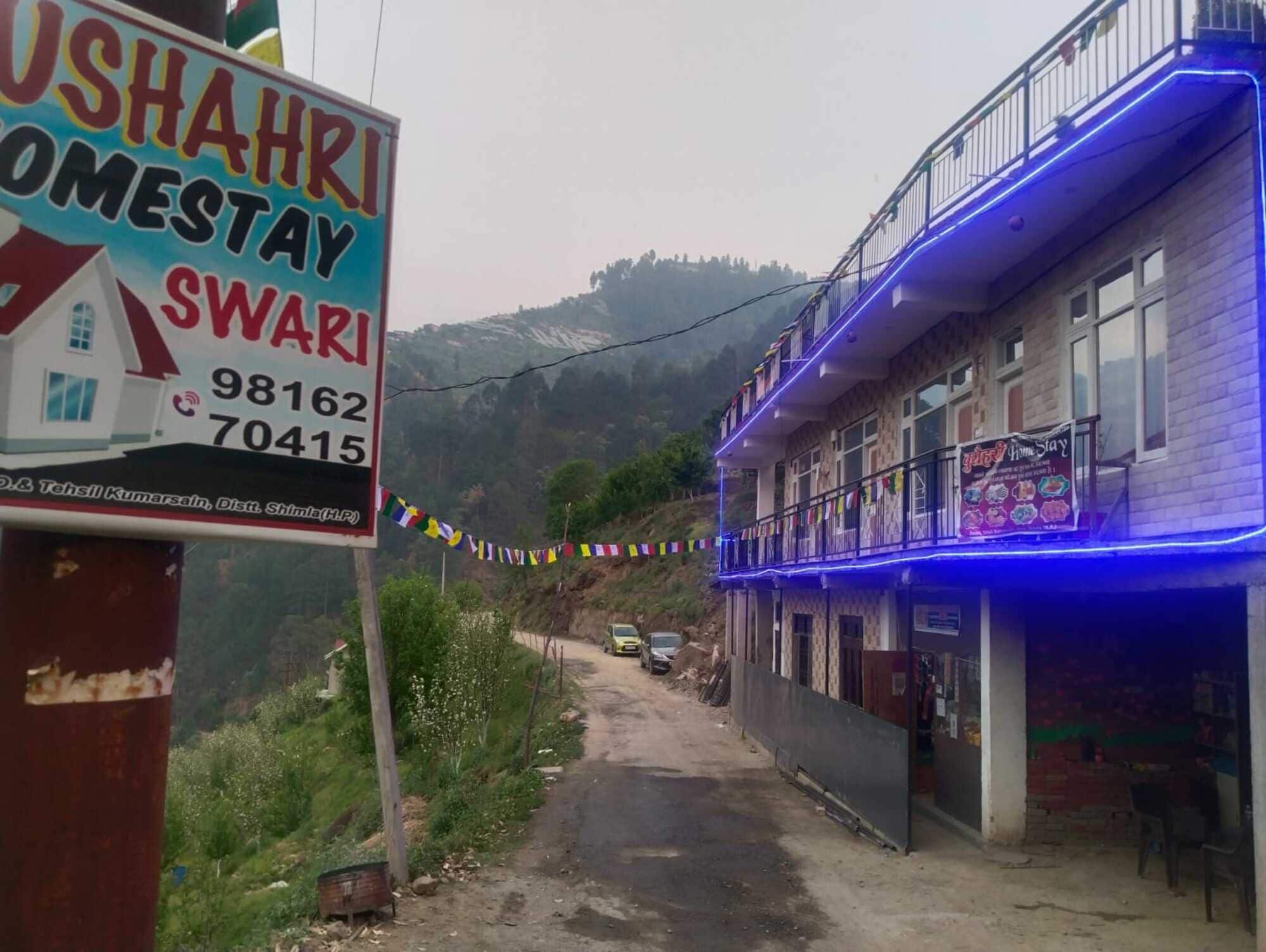 A sign for a homestay named "USHAHRI SWARI" with contact numbers.