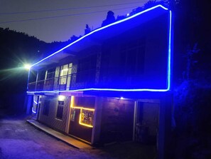 Un edificio a due piani con un balcone e un ingresso al piano terra.