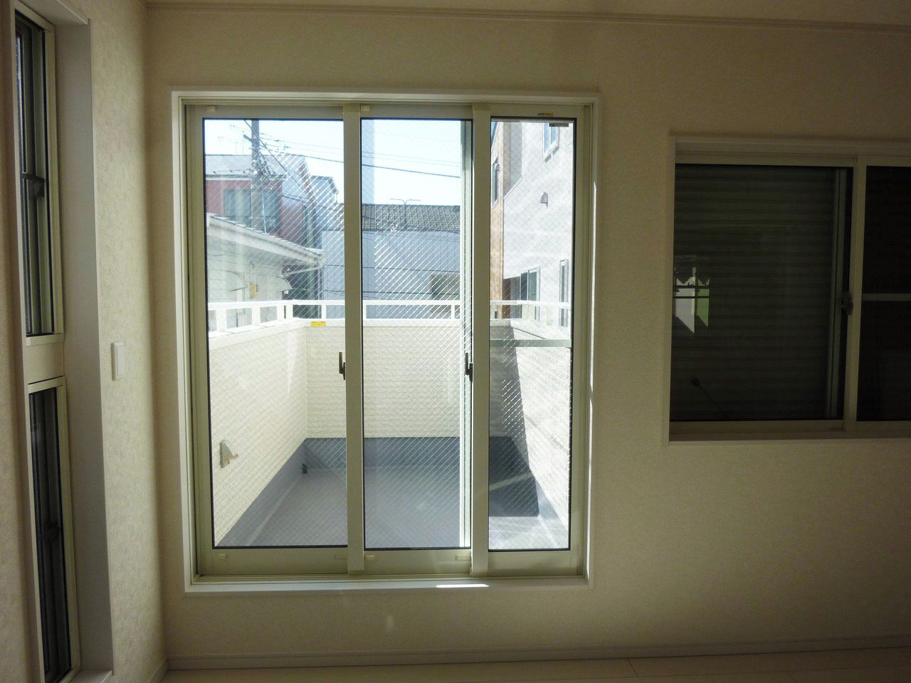 A room with a large sliding glass door leading to a balcony.