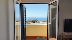 A balcony with a view of the sea and buildings.
