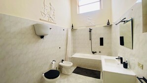 A modern bathroom with a toilet, bidet, bathtub, and a large mirror. - Domus Evora - Period home in the historic center (Tropea)