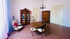 A dining room with a wooden table and chairs, a bookshelf, and two wardrobes. - Domus Evora - Period home in the historic center (Tropea)
