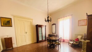 A spacious living room with a dining area, a chandelier, and a large mirror. - Domus Evora - Period home in the historic center (Tropea)