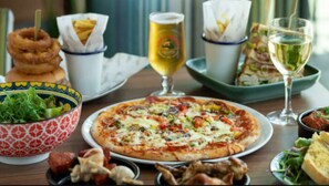 A table with a pizza, salad, sandwiches, and drinks. - Casita De Cuervo at Country Park (Lymington)