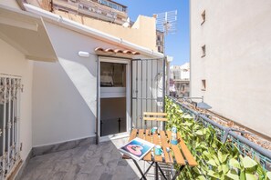 Ein Balkon mit Tisch, Stühlen und einer Zeitschrift.