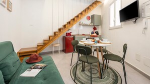 A modern living space with a staircase, a dining area, and a flat-screen TV.