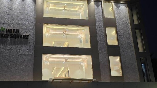 A hotel facade with multiple illuminated windows and a sign reading "HOTEL SAGI SQUARE". - Hotel Itagi Square (Vijayapura)