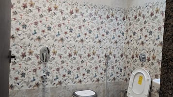A bathroom with a toilet, bidet, and shower.