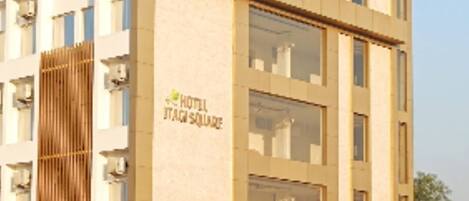 A multi-story hotel with a sign reading "HOTEL ITAGI SQUARE".