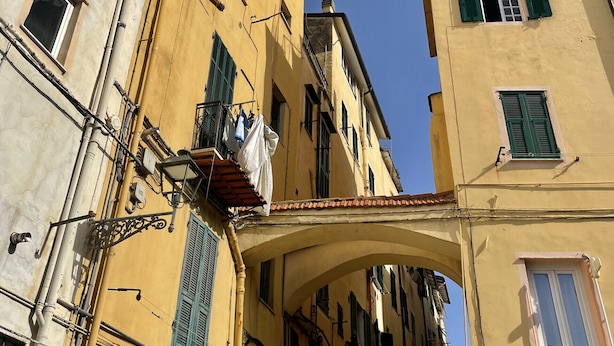 A narrow street with buildings featuring balconies and awnings. - Ancient House by Wonderful Italy (Sanremo)