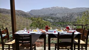 A table set for a meal with a mountain view in the background. - A traditional mountain gîte with swimming pool and local cuisine! (Κρουσώνας)