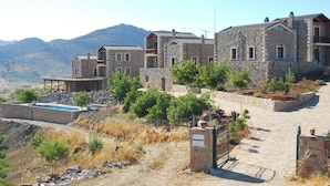 A stone building with multiple rooms, a swimming pool, and a mountainous backdrop. - A traditional mountain gîte with swimming pool and local cuisine! (Κρουσώνας)