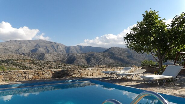 A clear blue pool with metal railings, surrounded by stone walls and white lounge chairs. - A traditional mountain gîte with swimming pool and local cuisine! (Κρουσώνας)