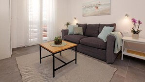 Ein Wohnzimmer mit einer Couch, einem Couchtisch und einem Bild an der Wand.