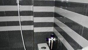 A bathroom with a toilet, a bidet, and a bucket. - SRI NAVANEETHA KRISHNA MAHAL & RESIDENCY (Andipatti)
