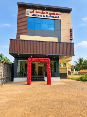 Un hotel con fachada moderna, un cartel que indica 'habitaciones' y 'Lounge & Bar', y un arco decorativo en la entrada.