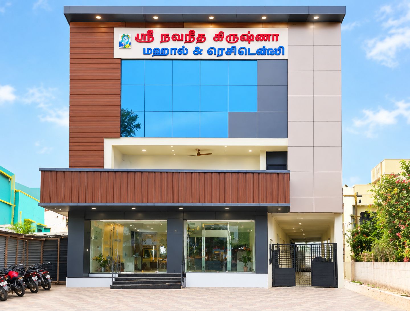 A modern building with a sign in two languages, large windows, and a gated entrance.