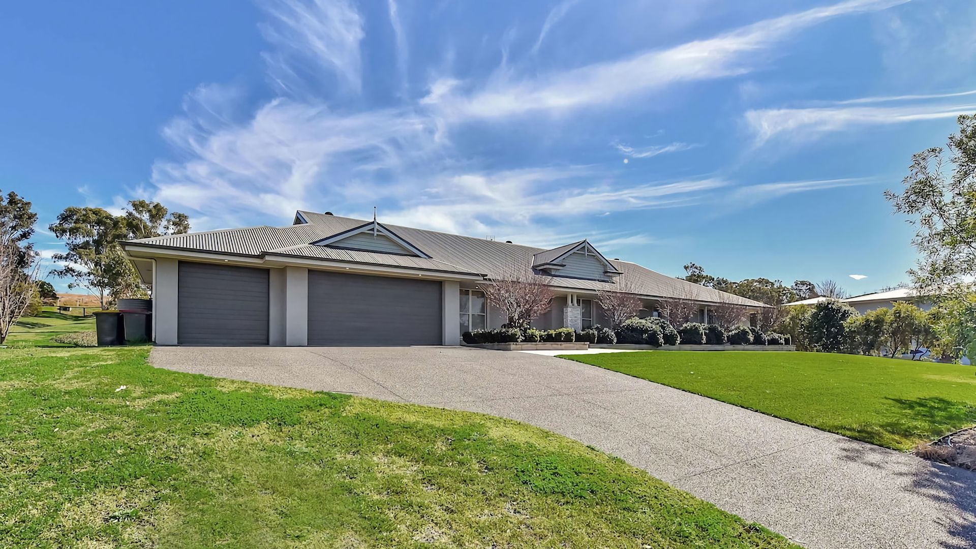 A residential property with a garage, a driveway, and a well-maintained lawn.
