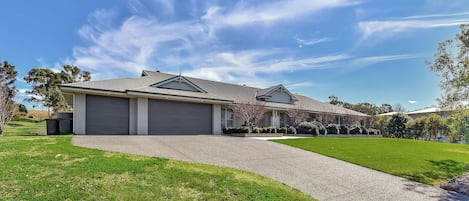 A residential property with a garage, a driveway, and a well-maintained lawn.