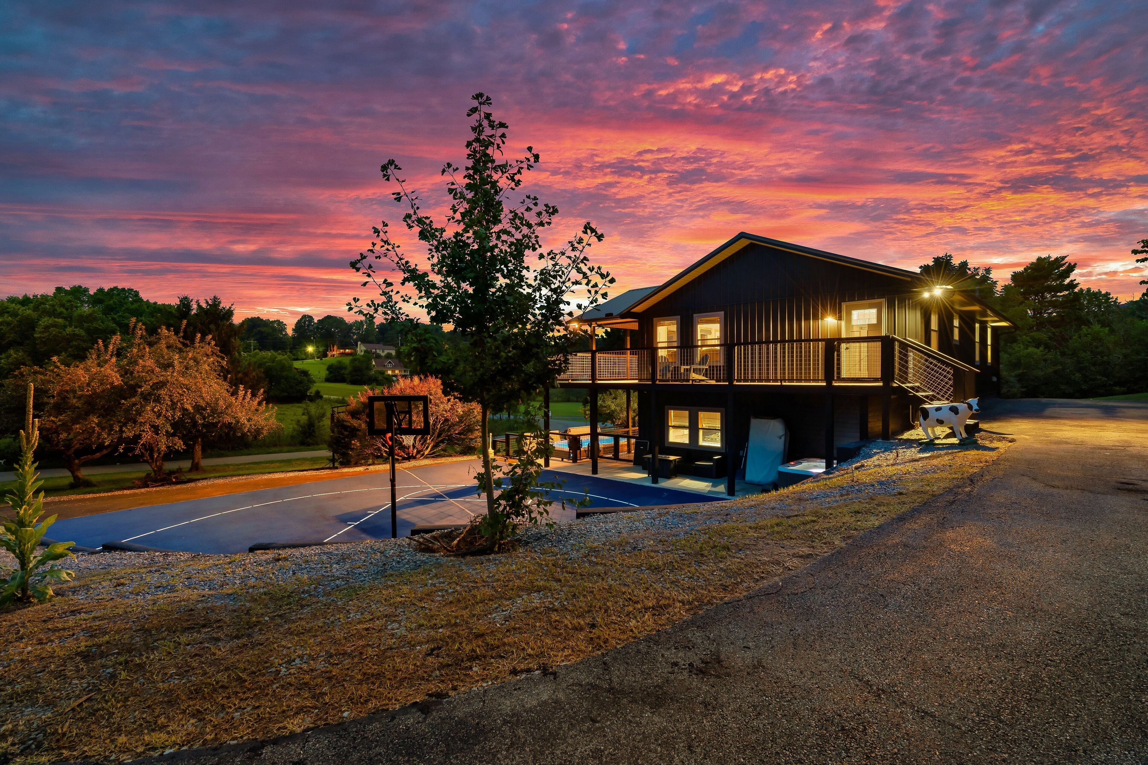 A two-story building with a balcony, a covered outdoor seating area, and a view of the surrounding landscape.