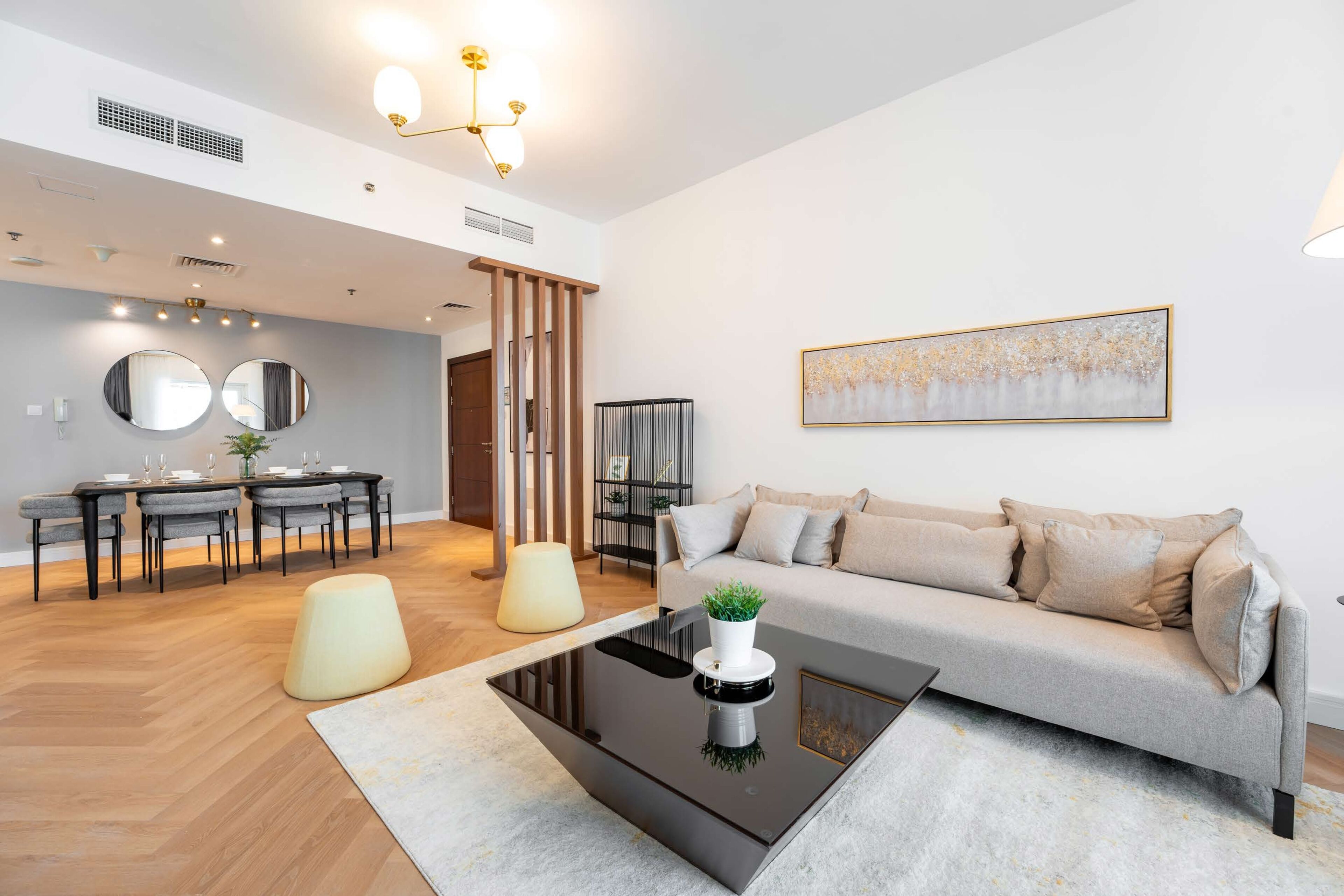 A modern living room with a sofa, coffee table, and dining area.