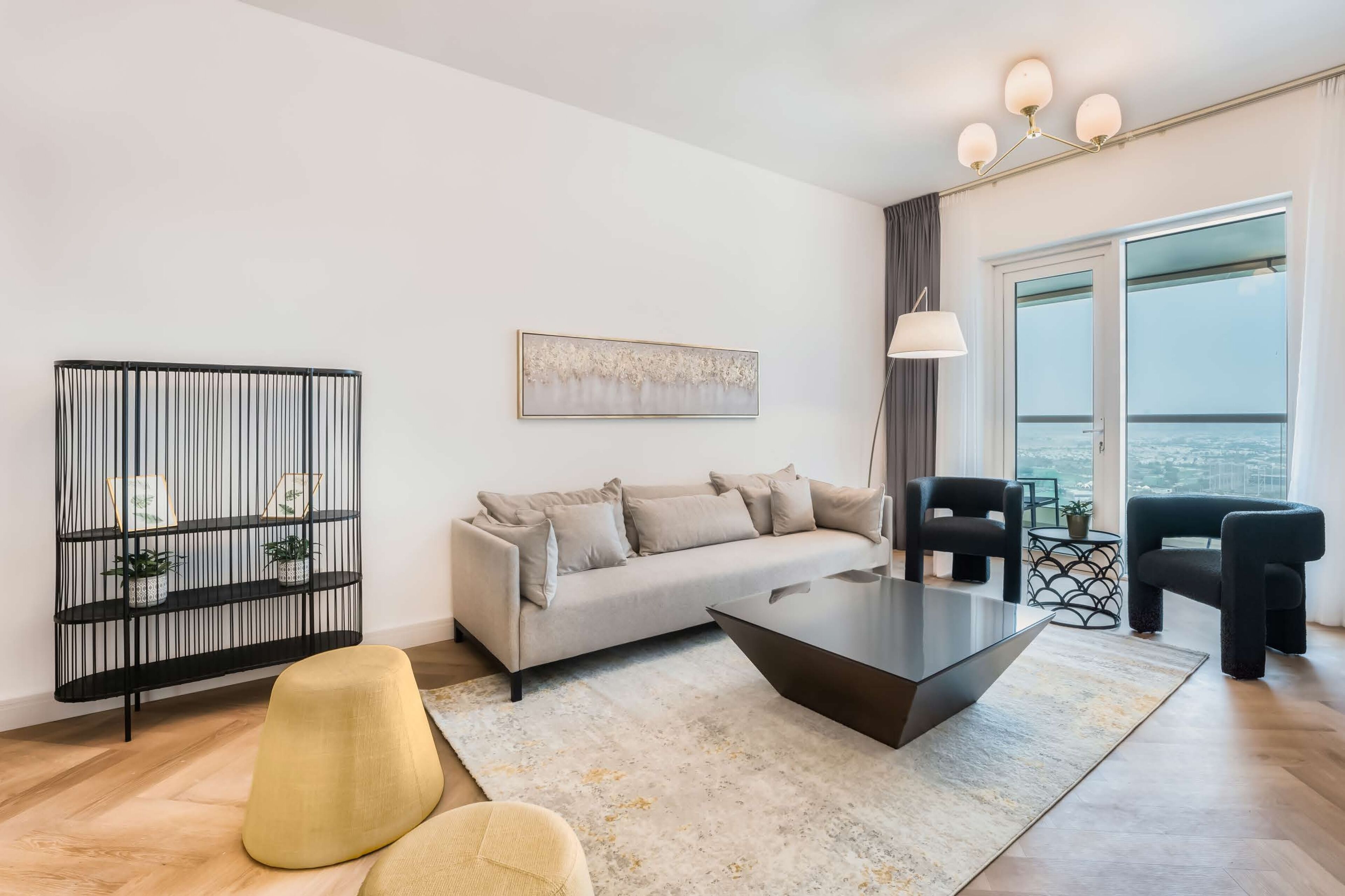 A modern living room with a sofa, a coffee table, and a black console table with plants.
