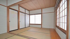 A traditional Japanese room with tatami flooring, sliding doors, and large windows. - K&K HOUSE (Takasaki)