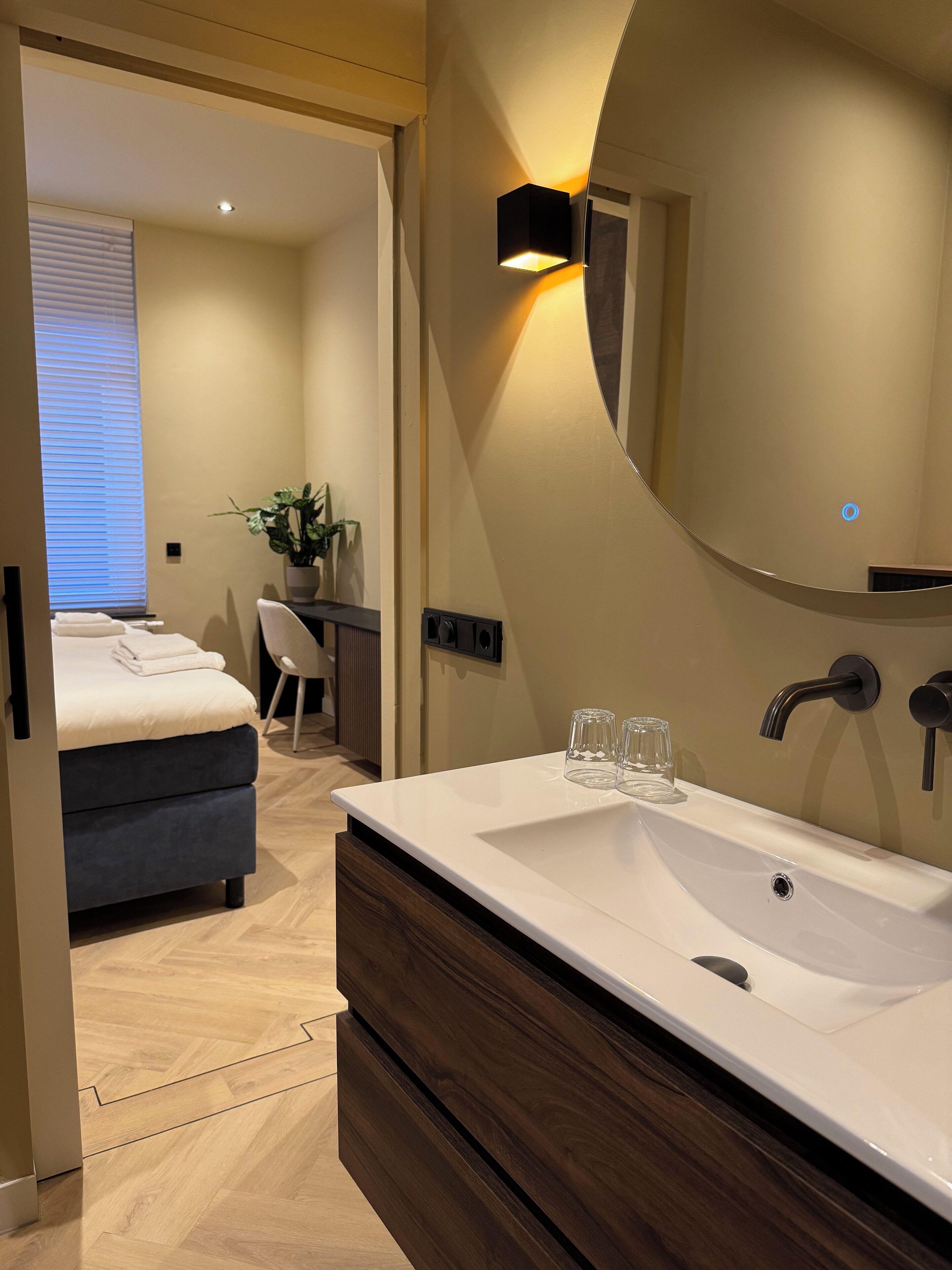 Een moderne badkamer met een ruime wastafel, een spiegel en een handdoekhouder.