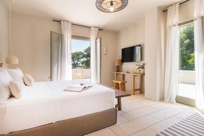 Une chambre moderne avec un grand lit, un bureau et une télévision.