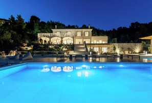 Une piscine avec des chaises longues et un mur en pierre.
