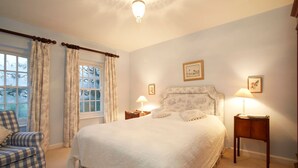 A bedroom with a large bed, two bedside tables with lamps, a chair, and a window with curtains. - Historic Hall Wing nr York Leeds Free Hot tub (Tadcaster)