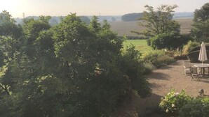 A view of a countryside landscape with a dirt path, a table with chairs, and a large tree in the foreground. - Historic Hall Wing nr York Leeds Free Hot tub (Tadcaster)