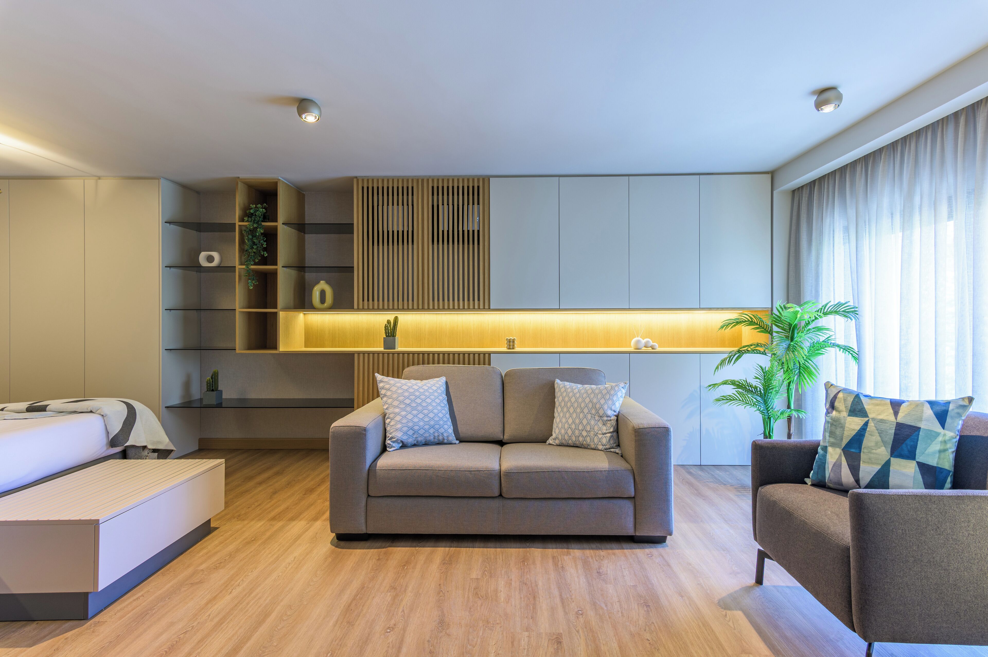 Una sala de estar moderna con un sofá, una mesa de centro y un comedor con estantería empotrada.