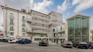 Un edificio moderno con un diseño arquitectónico único, que presenta una fachada inclinada y una entrada de vidrio.