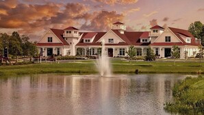A large, multi-story building with a symmetrical facade, a central fountain, and a well-maintained lawn. - Coastal Club* Resort House w 5 BR, 3.5 Baths - Sleeps 12 (Lewes)