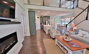 A spacious living area with a fireplace, a dining table, and a sofa.